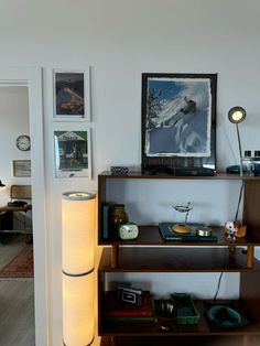 a living room filled with furniture and pictures on the wall next to a shelf full of books