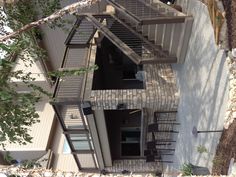 an outdoor patio with stairs leading up to the deck and dining room table on the other side