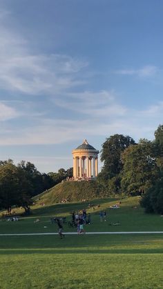 people sitting on the grass in front of a monument