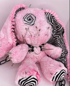 a pink stuffed animal with zebra print on it's chest and ear pieces around its neck