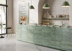 a kitchen with green tile counter tops and hanging lights