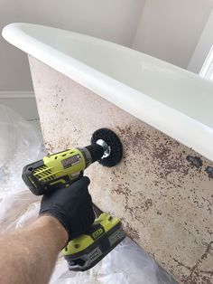 a person using a drill to fix a bathtub