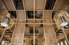 the interior of a restaurant with wooden ceiling and decorative lighting hanging from it's rafters