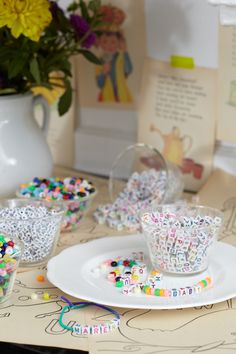 a table topped with plates and cups filled with candy