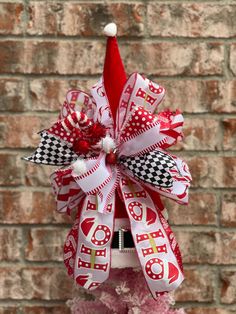 a red and white christmas decoration on top of a pink tree with a santa hat