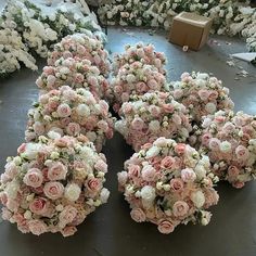 several large bouquets of pink and white flowers are arranged on the floor next to each other