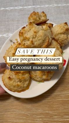 a person holding a plate with some food on it and the words save this easy pregnancy dessert coconut macaroons