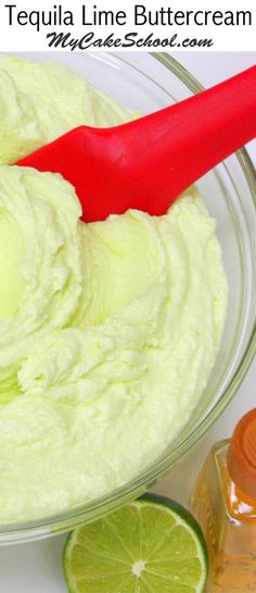 a red spatula in a glass bowl filled with limes and mayonnaise