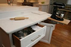 an open drawer in the middle of a kitchen counter