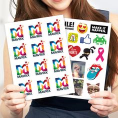 a woman holding up some stickers in her hands