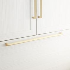 a white cabinet with brass handles on it