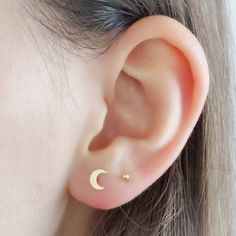 a woman's ear with a crescent piercing