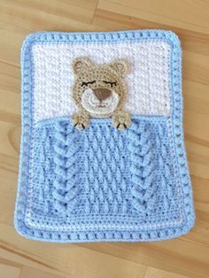 a crocheted blanket with a teddy bear on it