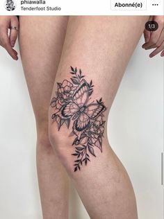 a woman's legs with tattoos on them and flowers in the middle of her leg