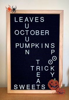 a wooden frame with words written on it and a fake pumpkin sitting next to it