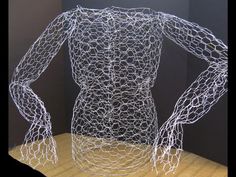 a wire sculpture sitting on top of a wooden table