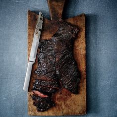 a steak on a cutting board with a knife