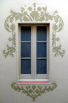 the window is decorated with green and white designs on it's side wall,