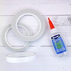 the supplies needed to make this diy wreath are laid out on a white wooden surface