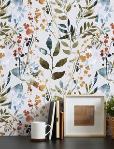 the wallpaper is decorated with colorful flowers and leaves, along with a coffee mug