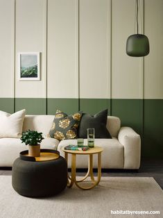 a living room filled with furniture and green accented wallpaper on the walls, along with a round coffee table