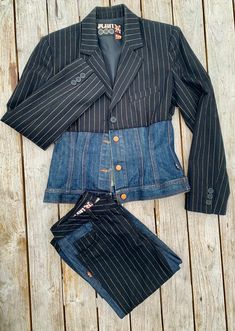 a denim jacket and pants are laid out on a wooden surface, with the shirt tucked in