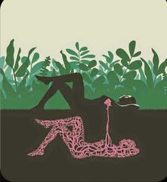 a person laying on the ground in front of some plants with a pink string attached to it