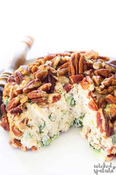 a white plate topped with a cake covered in pecans and other toppings on top of it