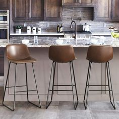 three stools sit in front of a kitchen island