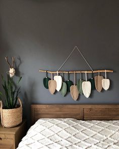 a bed with a wooden headboard and four heart shaped pillows hanging on the wall