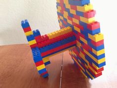 a lego chair sitting on top of a wooden table next to a building block structure