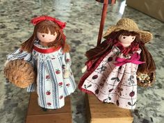 two doll figurines sitting on top of wooden blocks