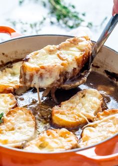 a close up of food in a pan on a table with a fork and spoon