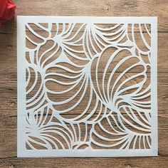 a piece of paper cut out to look like an intricate design on a wooden surface