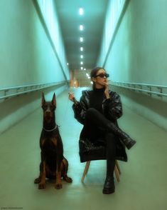 a woman sitting in a chair next to a dog