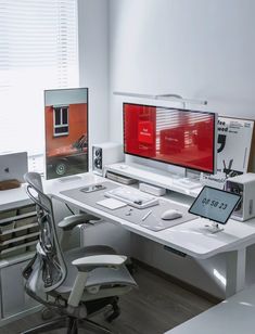 an office desk with two monitors and a laptop