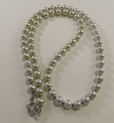 This is a white pearl necklace with tiny silver beads between the pearls.  It is 26 inches long with a toggle clasp. Everyday pearl necklace. Pearl Beaded Necklace With Lobster Clasp, White Pearl Toggle Necklace With Pearl Charm, White Pearl Toggle Necklace With Pearl Pendant, White Pearl Beaded Necklace, Necklace Everyday, White Pearl Necklace, Silver Bead Necklace, Silver Bead, Toggle Clasp