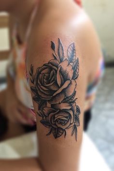 a woman's arm with a rose tattoo on the left side of her arm