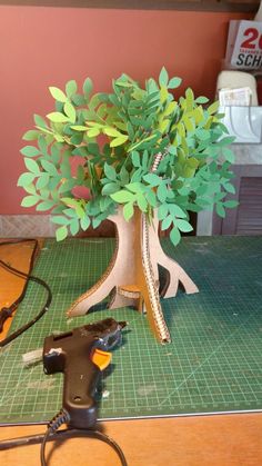 a plant is being made out of cardboard and some tools are laying on the table