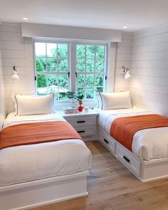 two beds in a room with white walls and wood floors