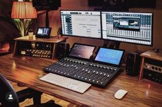 there is a desk with two computer monitors and sound equipment on it, along with several other electronic devices