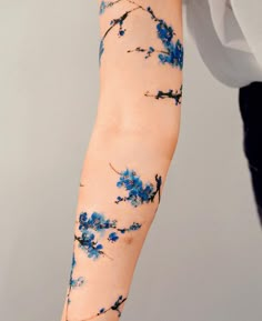 a woman's arm with blue flowers on it