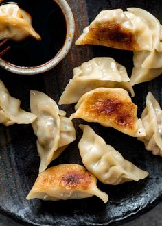 some dumplings on a plate with dipping sauce