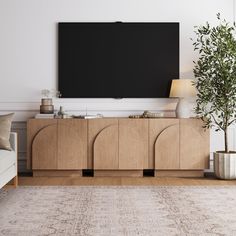 a large flat screen tv mounted to the side of a wooden cabinet in a living room