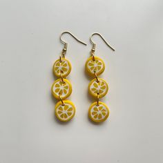 three slices of lemon are hanging from earrings