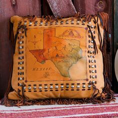 a brown leather pillow sitting on top of a wooden floor