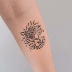 a small tiger tattoo on the right arm and leg, with leaves around it's neck