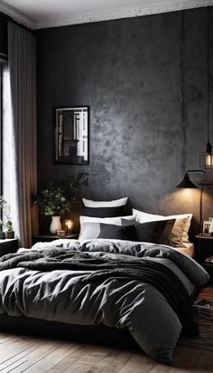 a bedroom with black walls and wooden flooring is lit by two lamps on either side of the bed