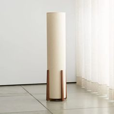 a tall white cylinder sitting on top of a tiled floor