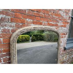 an old mirror on the side of a brick wall